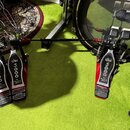 Dvojpedál na buben v červeno-černé barvě s kovovými komponenty. Na všech třech stupňích je vidět logo DW a nápis 5000, dále text The Drummer's Choice…