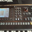 Černý digitální klavír s displejem a ovládacími prvky. Na displeji je vidět seznam zvuků, včetně nápisů AC Piano, NaturalPiano, SuperiorPiano, Classi…