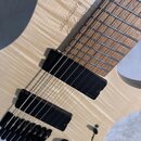Detail elektrické kytary s tělem z vyvytvarovaného světlého dřeva s viditnou strukturou zrn. Na těle je nápis „strandberg“ a pod ním podpis. Nástroj…