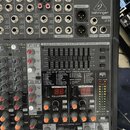 Detailní pohled na míchací pult stříbrné barvy s černými ovládacími prvky. V horní části je nápis EURODESK SX2442FX, ULTRA-LOW NOISE DESIGN 24-INPUT…