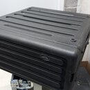Černý plastový kufřík s žebrovaným povrchem na horní i přední straně. Na předním panelu je umístěno oválné logo s nápisem "m-audio". Povrch vykazuje…