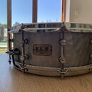 Šedý buben s povrchem v optice kovaného kovu a chromovaným obručováním. Na korpusu je umístěn štít s nápisy S.L.A, SOUND LAB PROJECT a TAMA. Nástroj…