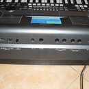 Detailní pohled na zadní panel šedého digitálního klavíru značky YAMAHA. Jsou vidět konektory s popisky TO DEVICE USB, TO HOST, LCD CONTRAST, AUX IN,…