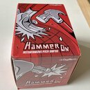 Krabice s nápisem HammerON INSTANTANEOUS PITCH SHIFTER a logem Digitech. Povrch krabice je červený s grafikou kladivem a stříbrnými prvky. Rohy krabi…