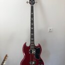 Čtyřstrunná basová kytara s červeným lesklým povrchem těla a černou hlavou. Na hlavě je nápis Epiphone. Tělo má charakteristický SG tvar, černý pickg…