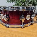 Vícevrstvý červený buben s chromovaným obručováním a napínacími šrouby. Na korpusu jsou umístěny dvě oválná loga s nápisy drum dw Custom Series. Povr…