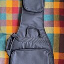 Černý polstvuovaný obal na basovou kytaru s dvěma zipovými kapsami a popruhem pro přenášení. V pravém dolním rohu je žluté logo s nápisem Mark bass.…