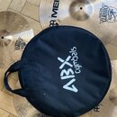 Fotografie zachycuje sadu mosazných činelů a černý přepravní obal. Na činelech je vidět nápis MEINL a logo s textem CLASSICS. Na černém obalu je bílý…