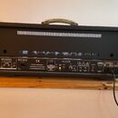 Zadní strana černého kytarového komba s kovovou rukojetí. Na ovládacím panelu jsou nápisy SPEAKERS, RED BOX, CE a FX LOOP. Jsou zde vidět vstupy a vý…