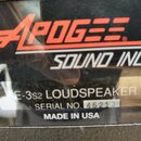 Detailní záběr na štítek zařízení. Je na něm červený nápis APOGEE, pod ním bílý text SOUND INC. a dále označení E-3s2 LOUDSPEAKER, SERIAL NO. 46213 a…