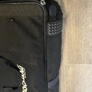 Černý textilní obal na hudební nástroj s bílým nápisem ROCBAG by Warwick. Na boku jsou umístěny dvě černé gumové protiskluzové plochy s pyramidovitým…