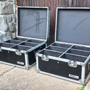 Dvě otevřené černé transportní bedny z materiálu s hliníkovým profilem a kovovým kováním. Vnitřní prostor každé bedny je rozdělen na šest přihrádek a…