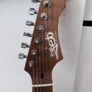 Fotografie zachycuje hlavu elektrické kytary z hnědého dřeva s viditnou masivním strukturou. Na povrchu je bílé logo Jet a nápis JET GUITARS. Nástroj…
