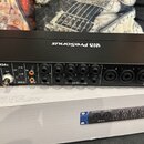 Černý rackový audio rozhraní s nápisem PreSonus STUDIO 1824c. Přední panel obsahuje různé konektory, včetně MIDI, ADAT I/O a řady vstupů označených j…