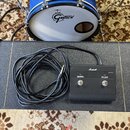 Fotografie ukazuje modrý buben značky GRETSCH s bílým koženem a černý nožní spínač Marshall. Spínač má nápisy CHANNEL, FX LOOP a v pravém horním rohu…