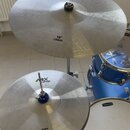 Fotografie zachycuje část modrého bicího setu se dvěma činely. Horní činel má nápis ABX Cymbals a 18" CRASH, spodní činel nápis ABX Cymbals a 13" HIH…
