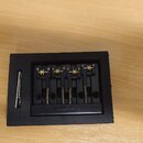 Černý kovový kobylka pro elektrickou kytaru s čtyřmi sedly a zlatými šroubky. Na spodní části je vyražen nápis guylar. Celý mechanismus je umístěn v…