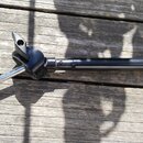 Černý mikrofonní stojan s kovovou teleskopickou horní částí. Na kloubu a spodní části trubky je vidět černý lak, horní segment je chromovaný. Na konc…