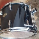 Černý buben s chromovaným obručováním a mechanismy. Na korpusu je oválný zlatý štítek s nápisem Masters. Na spodním obruči je viditelný nápis Pearl M…
