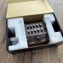 Černý kytarový procesor Acoustic Preamp v kartonové krabici s bílým polystyrenem. Na horním panelu jsou ovládací knoflíky a přepínače s nápisy ACQUST…