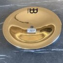 Zlatavý kovový činel s hladkým povrchem. Na horní části je černý nápis MEINL a stylizované logo v podobě velkého písmene B. Uprostřed je nalepená bíl…