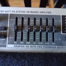 Detail ovládacího panelu zesilovače s nápisem FX 180-WATT PA SYSTEM/KEYBOARD AMPLIFIER. V centru je grafický ekvalizér s šesti posuvníky a označením…