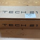 Hnědá kartonová krabice s černým nápisem TECH 21 na horní i boční straně. Na horní části je bílá papírová nálepka s čárovým kódem a textem 611272, Te…