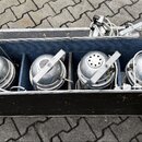 V černém transportním kufru s hliníkovým profilem a modrým vnitřním polstrováním je umístěno pět stříbrných reflektorů. Každý reflektor má kulatý tva…