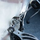 Detailní záběr na mechanismus basového pedálu u bubnu. Je vidět kovová řetězová spojka, hřídel a část pedálu z nerezové oceli. Povrch kovových částí…