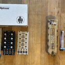 Fotografie zobrazuje dva moduly pro Eurorack syntetizátory značky Quadra, bílý karton s nápisem intellijel designs a balení v hnědém papíře s nápisem…