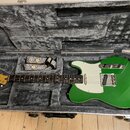 Zelená elektrická kytara typu Telecaster s bílým pickguardem v otevřeném hrdelním kufru s šedou plišovou výstuhou. Na hlavě kytary je nápis Fender. V…