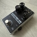 Stříbrný efekt pedál s černým horním panelem. Na panelu je bílý nápis MICROTUBES B3K CMOS Bass Overdrive a tři černé ovládací knoflíky s popisky LEVE…