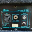 Záběr na zadní panel reproduktorového systému černé barvy s nápisy „élite“ a „micron 600“. Na modrém štítku je text „PROFESSIONAL SOUND REINFORCEMENT…
