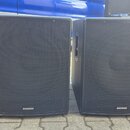 Dva černé reproduktory v hranatých bednách s kovovými ochrannými mřížkami. V pravém dolním rohu každého reproduktoru je bílý nápis SAMSON. Povrch bed…