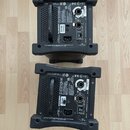 Fotografie zachycuje zadní stranu dvou černých elektronických zařízení značky ALLEN&HEATH, model DX168 AudioRack. Jsou vidět napájecí konektory, síťo…