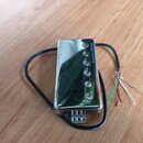 Elektrický snímač s chromovaným krytem a šesti viditelnými polosnovými šrouby. Na pravém okraku krytu je svisle napsán text Seymour Duncan. Z nástroj…