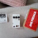 Bílé efektové pedál s nápisy REVERB, VERB, EQ a DECAY u ovládacích knoflíků. Na spodní části je logo JHS 3 SERIES a přepínač PRE-DELAY. Vedle pedálu…