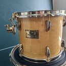 Světle hnědý buben s přirozeným Maserováním dřeva a chromovaným kováním. Na korpusu je umístěn štítek s nápisy Pearl, Masters Custom, MAPLE a MADE IN…