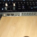 Černý drum machine s dřevěnými bočními panely. Na horní části je nápis DRUMBRUTE a na předním panelu logo ARTURIA. Zařízení má řadu bílých tlačítek,…