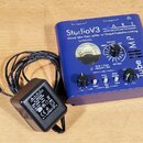 Modrý předzesilovač s nápisy StudioV3, ART APPLIED RESEARCH AND TECHNOLOGY a Tube MP. Zařízení obsahuje analogový VU metr, několik otočných ovladačů…