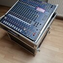 Modrý mixážní pult Yamaha MG166cx umístěný v černém transportním kufru s hliníkovými hranami. Na přístroji je v pravé horní části nalepený růžový ští…