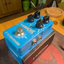 Modrý efekt pedál s nápisy FLASHBACK DELAY AND LOOPER a tc electronic. Na horní straně jsou čtyři černé oválné ovladače, stříbrný spínač a přepínač s…