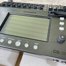 Digitální mixážní pult značky ALLEN&HEATH, model CQ-18T. Zařízení má černý kovový povrch s centrálním displejem a řadou ovládacích tlačítek, potencio…