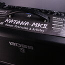 Černý kytarový kombozesilovač s texturovaným povrchem. Na horním panelu je bílý nápis KATANA MKII a pod ním motto Honor, Precision & Artistry. V prav…