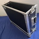 Černý transportní flightcase s hliníkovými hranami a kovovými rohy. Na boku je umístěna stříbrná rukojeť a v horní části pravého boku se nachází kovo…