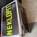 Černý transportní flightcase s hliníkovými hranami a rohy. Na horní straně je velký žlutý nápis NEKLOPT a malá nálepka s logem a textem WWW.NEKLOPT.C…
