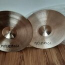 Dvě mosazné činely s jemným žebrováním povrchu. Na obou je vyražen nápis istanbul Agop Made in Turkey. Levý činel má v horní části malý nápis Top a o…
