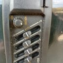 Černý ekvalizér s ovládacím knoflíkem VOLUME a čtyřmi posuvníky. Na panelu jsou nápisy BASS, MID, TREB a v dolní části označení EQ-7545. Povrch zaříz…