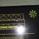Detailní záběr na horní část černého obalu nebo krabice s produktem. Je zde vidět grafika ovládacího panelu s nápisy Bass, Contour, Treble a Volume p…