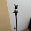 Detailní pohled na horní část chromovaného stojanu z kovu. V horní části je umístěn černý pěnový držák s křídlovým šroubem. Povrch chromu vykazuje zn…